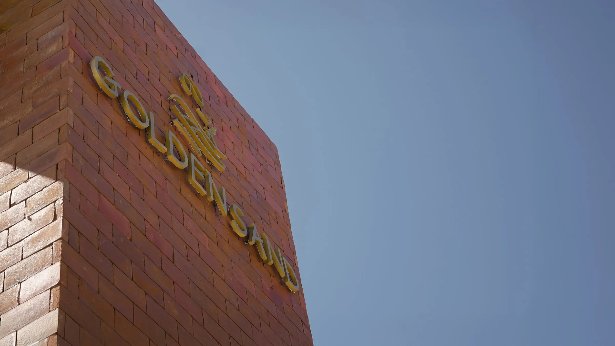 The Golden Sand sign under a blue sky