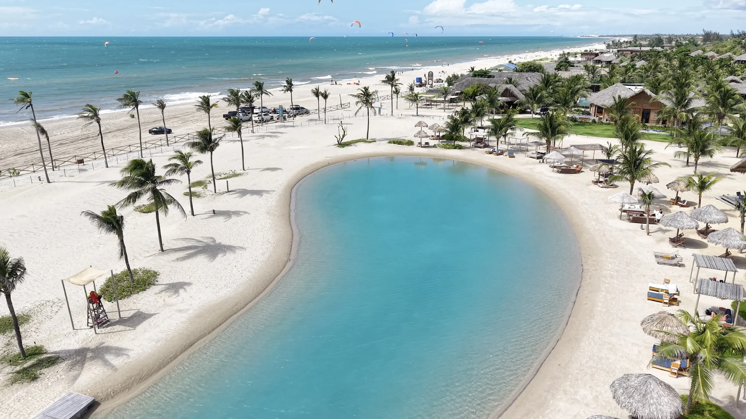Aerial view of the Carnaúba Wind House freshwater lagoon, with the beach club and the sea behind